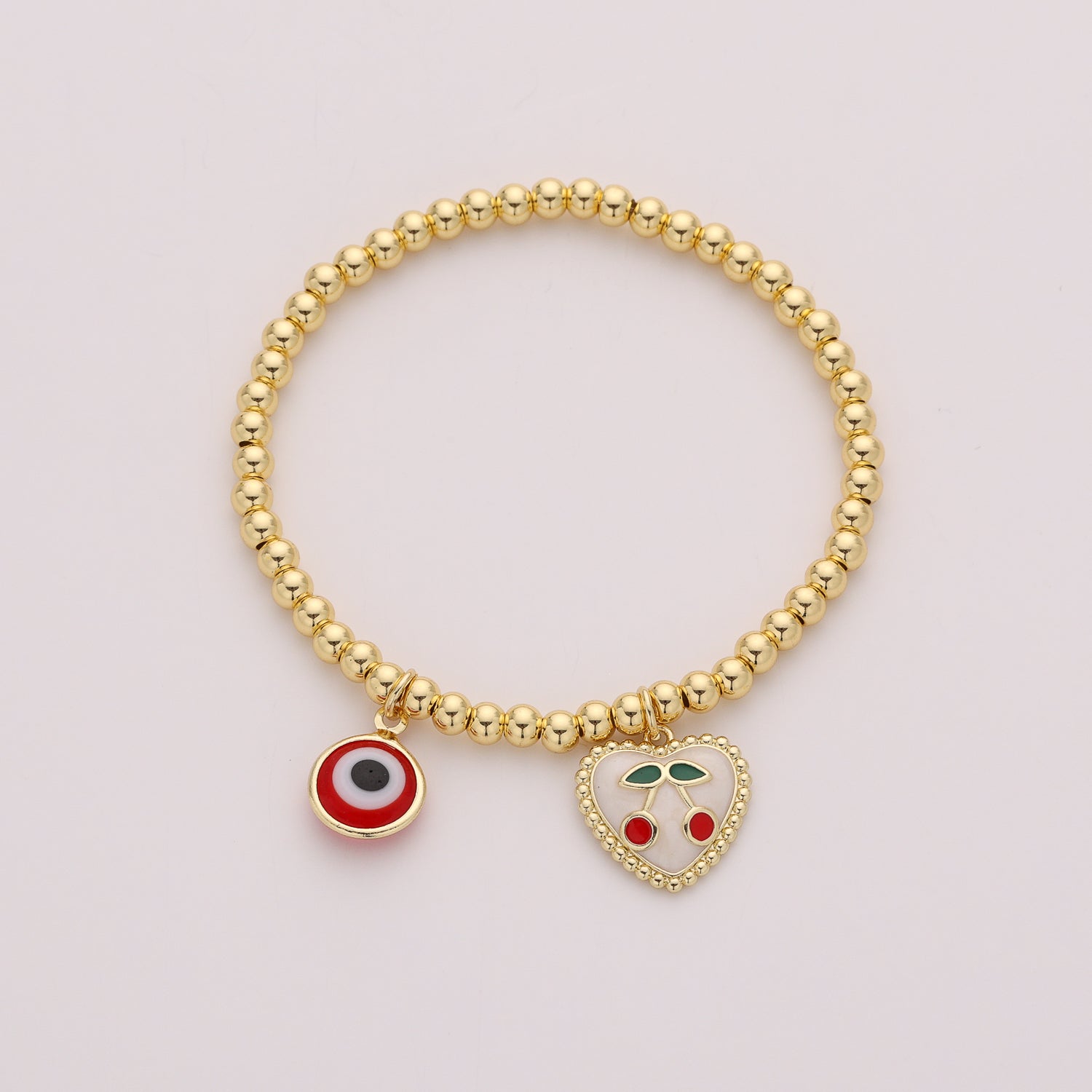 ELASTICO BOLAS DORADAS DIJE CORAZON ESMALTE CEREZA Y OJO / DORADO
