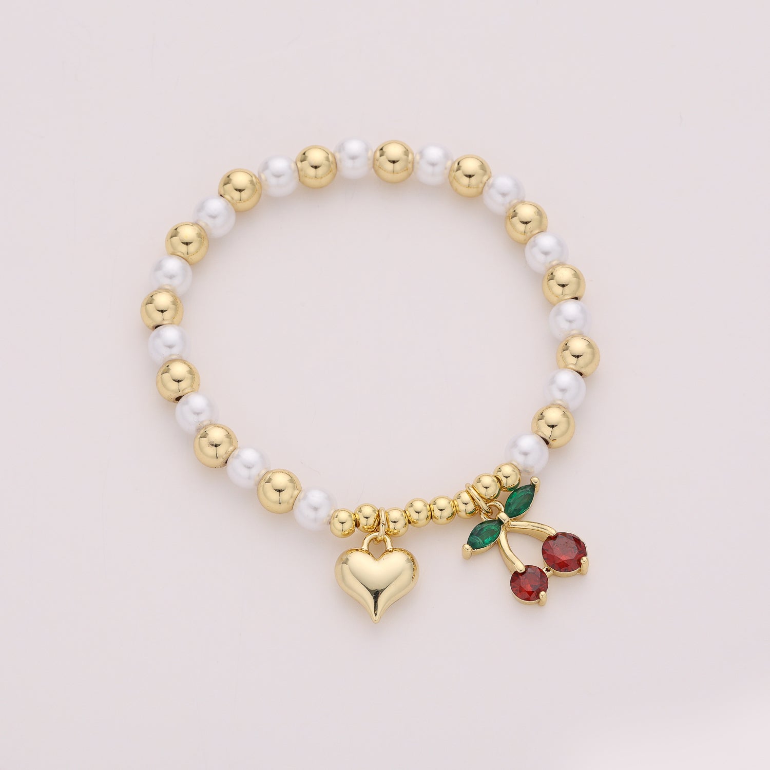 ELASTICO BOLAS DORADAS Y PERLAS  DIJE CEREZAS Y CORAZON / DORADO